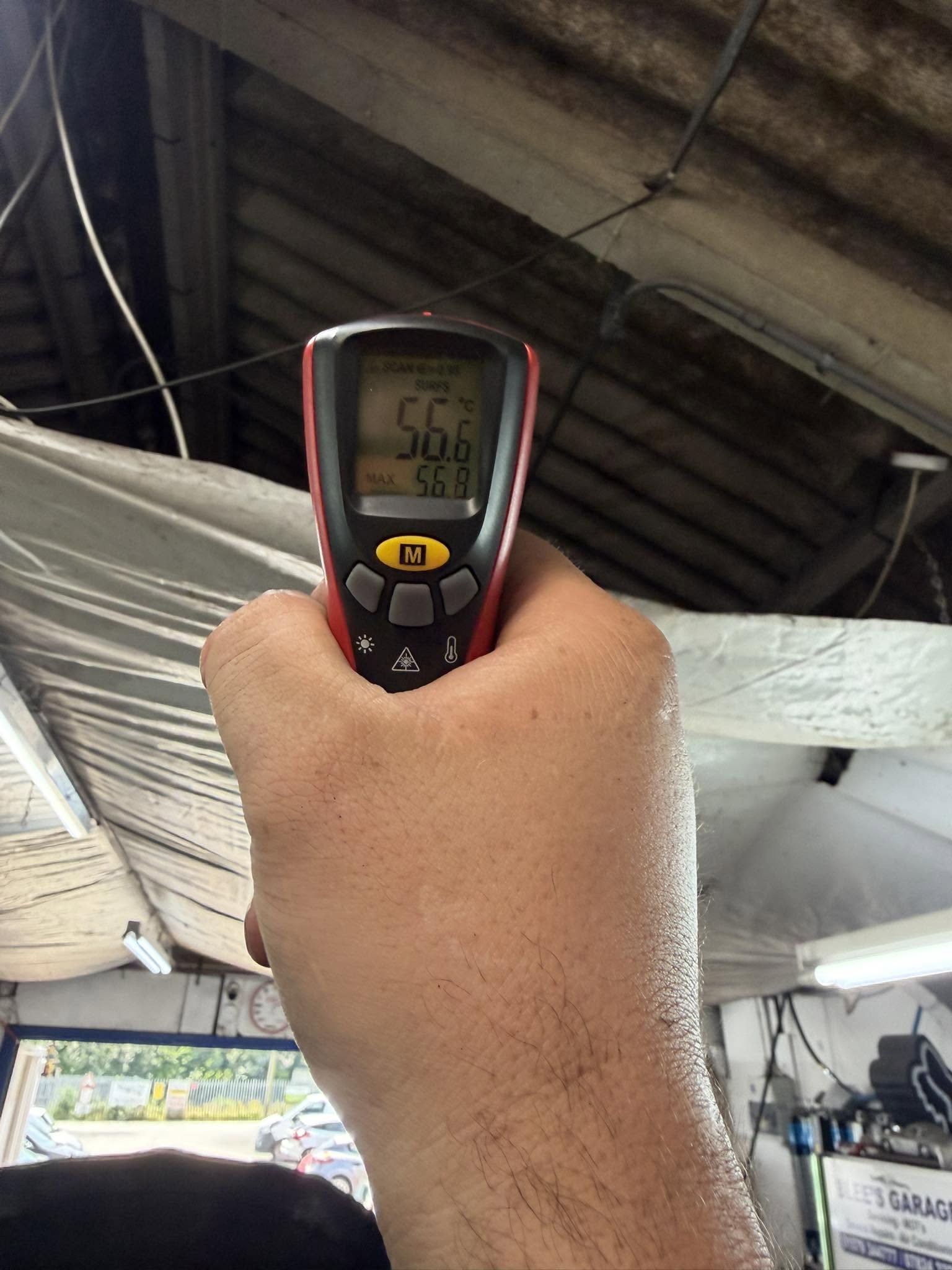 A thermometer held at a car's air vent