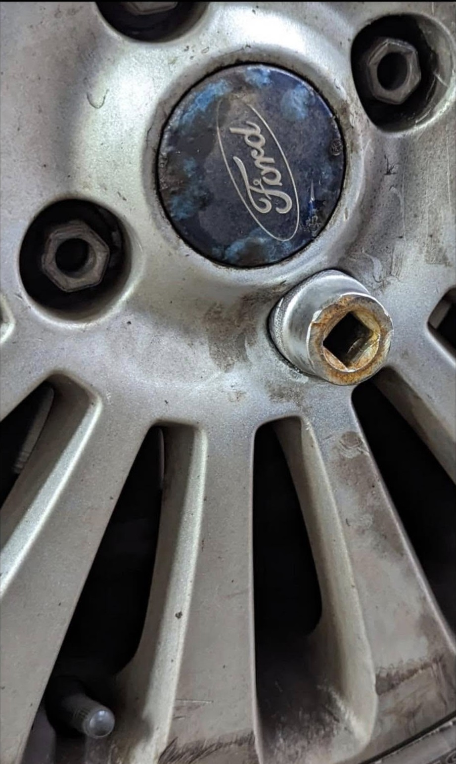 A locking wheel nut being taken off a Ford alloy wheel