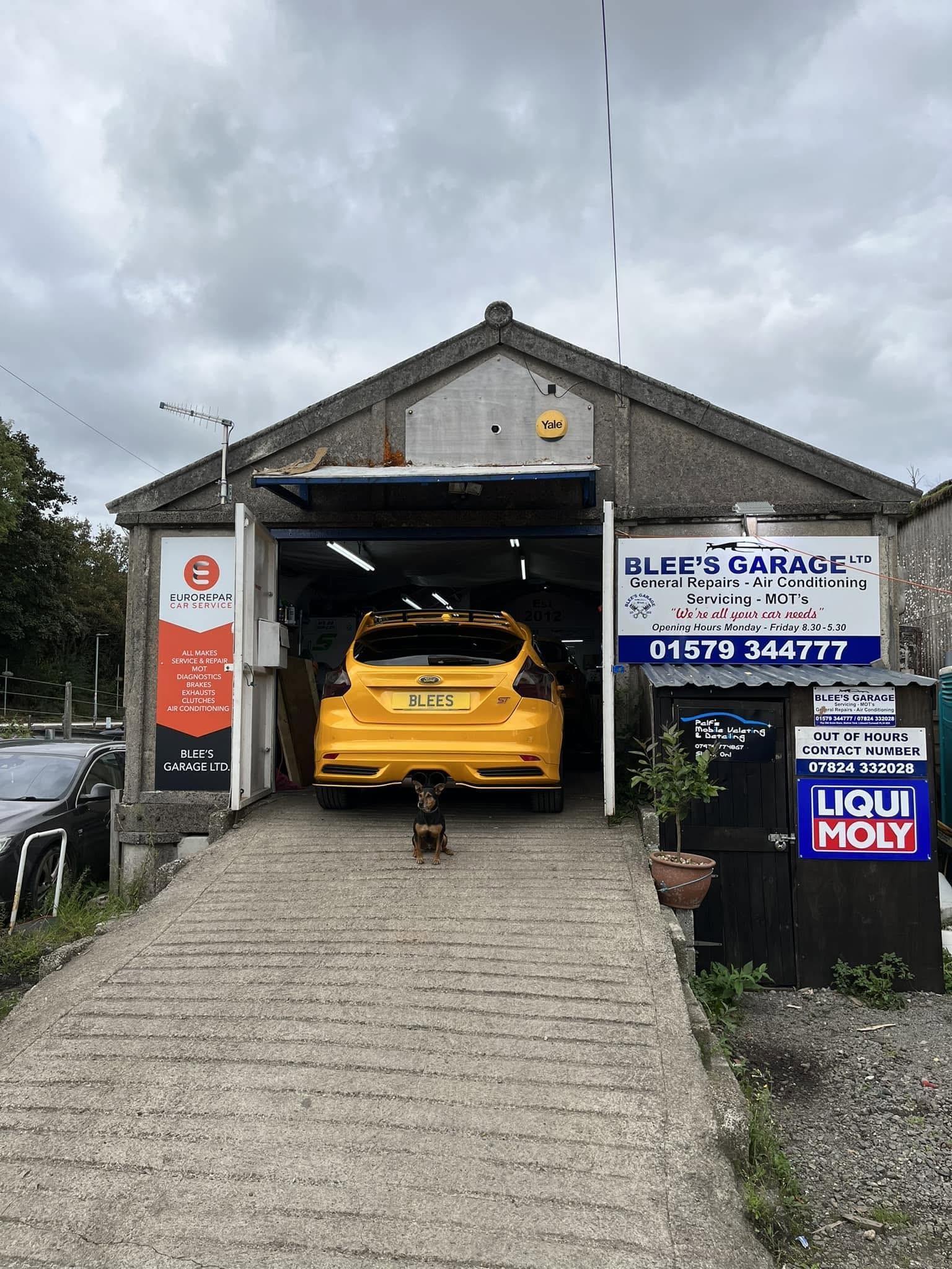 Blee's Garage workshop in Station Yard, a yellow Ford Focus up the ramp in the bay under the Blee's Garage sign