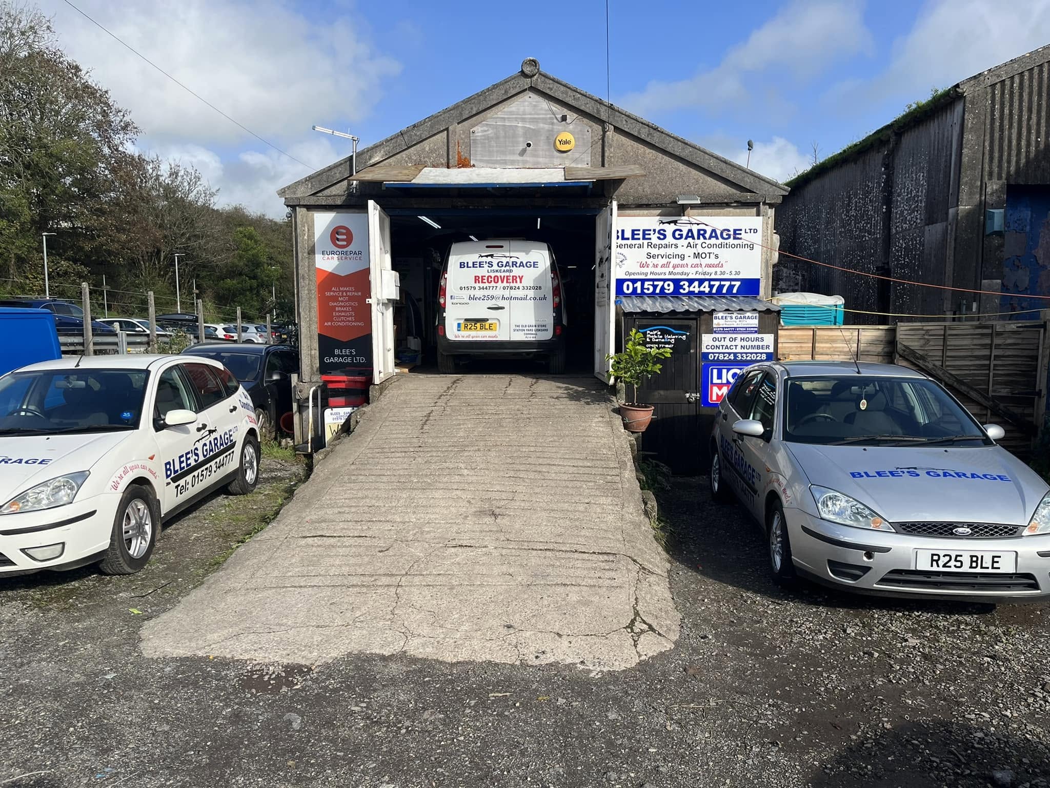 The concrete ramp up to the Blee's Garage workshop, with branded cars either side